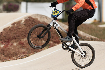 Young boy jumping with his BMX bike at pump track. BMX racing track. Cyclist riding on pump track....