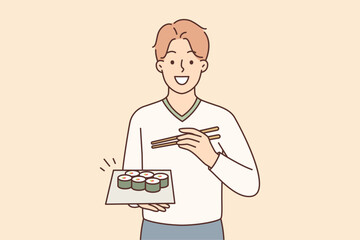 Man holding plate of maki rolls invites to dine in japanese restaurant with delicious healthy food