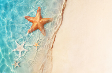 Fototapeta na wymiar Starfish on the sand beach in clear sea water. Summer background. Summer time .Copy space. Relaxing on the beach.