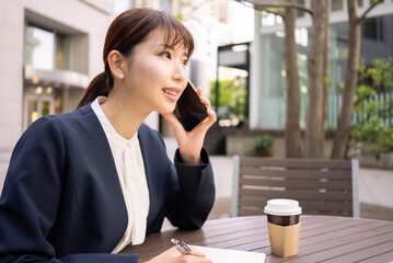 笑顔で電話をする日本人ビジネスウーマン