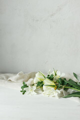 Beautiful white tulips and daffodils on soft fabric on rustic wooden table. Happy Mothers day. Stylish simple spring bouquet, floral still life. Womens day. Space for text
