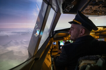 Caucasian bearded man controls the plane and looks at the beautiful sunset sky. 