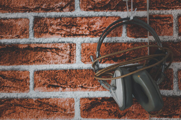 Fototapeta na wymiar Gray music headphones on brick background