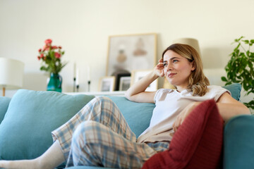 An attractive young woman relaxing at home in pajamas