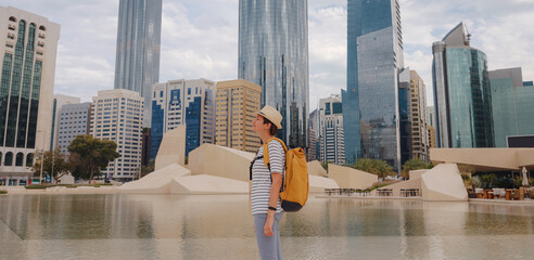 travel to the United Arab Emirates, Happy young asian female traveler with backpack and hat in big...
