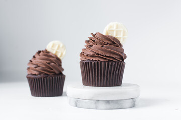 Chocolate cupcake with dark chocolate buttercream, double chocolate cupcakes with american buttercream, tall swirl frosting on a cupcake with a wafer