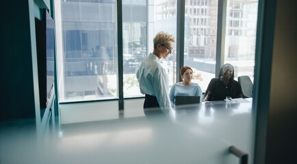 Female executive leading successful meeting with diverse colleagues in corporate office