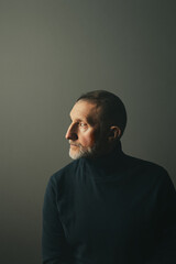 portrait of a handsome elderly man with a beard on a white background, close-up, in profile, selective focus