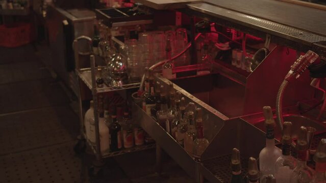 Bottles in the backside of the bar, different glass types in inventory, rustic and vintage atmosphere, captured during making music video for a rock band.