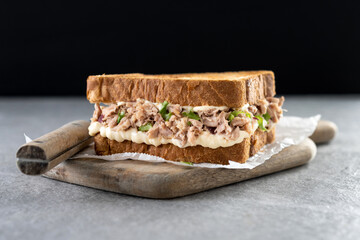 Tuna sandwich with mayo and vegetables on gray surface