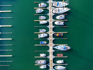 Aerial view of the many white yachts and sailboats moored in the marina on the turquoise water, summer season. Harbor in Poland Gdynia.