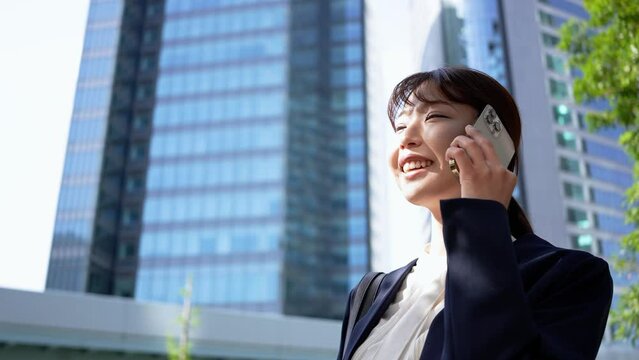 笑顔で電話をする日本人ビジネスウーマン