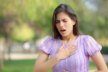 Woman suffering asthma attack in a park