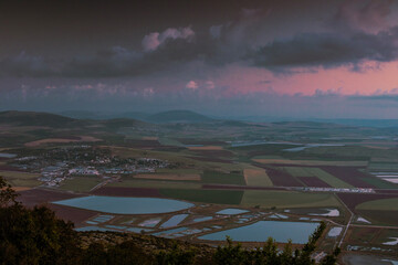 Asphalt road with Field and Village in cloudy day during sunrise in Israel