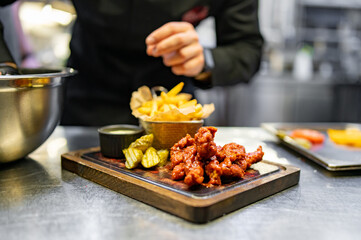 chef cookind chicken breast strips and french fries on restaurant kitchen