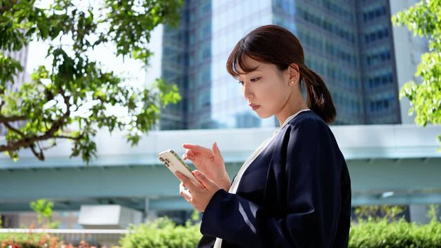 スマホを操作する日本人ビジネスウーマン