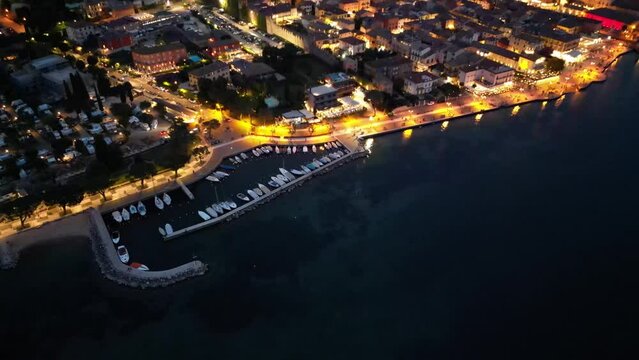 Aerial View Of Lazise Comune At Night With Marina On Lago di Garda In Italy.