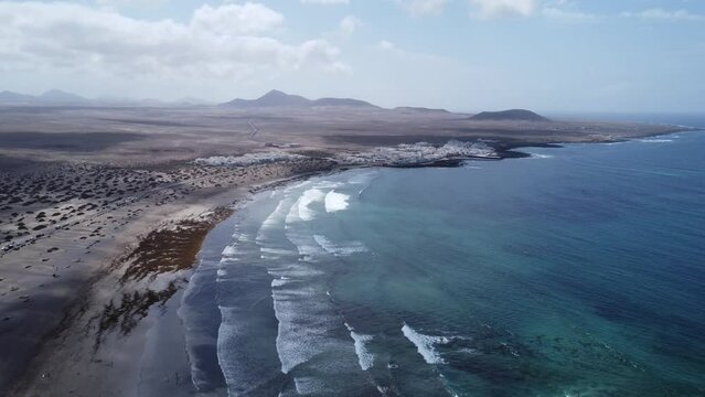 amazing sandy bay of famara in lanzarote (spain), waves and blue skies