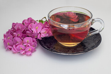 Lilac colored Acacia flower tea on a white background