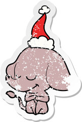 hand drawn distressed sticker cartoon of a smiling elephant wearing santa hat