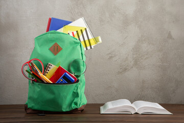 Back to school - books and school backpack on the desk in the auditorium, Education concept.
