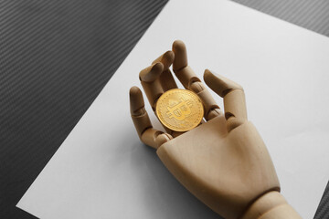 Artificial hand holding one bitcoin on white paper background. Virtual money concept and Financial growth concept. Trading Mining of bitcoins.