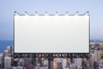 Blank white billboard on city buildings background at night, front view. Mockup, advertising concept