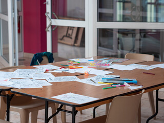 Table en désordre avec dessins d'enfants et feutres