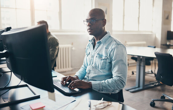 Businessman and a colleague working on computers in a bright office
