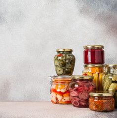 Preserving vegetables for the winter, canned vegetables in jars on a light background, pickled or fermented vegetables, copy space