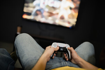 KYIV, UKRAINE - FEBRUARY 13, 2023: Cropped view of young man holding joystick in gaming club.