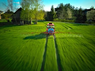 traktor opryskuje pola (panning z drona)