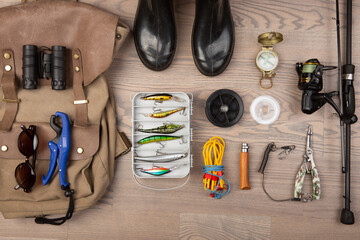 Fishing rod, tackles and other stuff for recreation activity on the wooden desk. Fishing season...