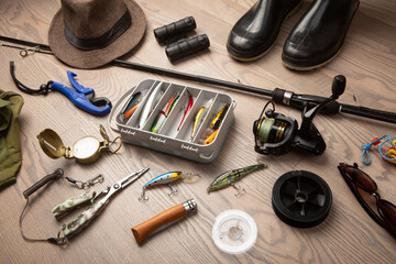 Fishing rod, tackles and other stuff for recreation activity on the wooden desk. Fishing season...