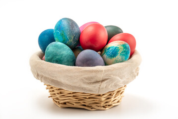 Multi colors Easter eggs in the woven basket isolated on white background with clipping path