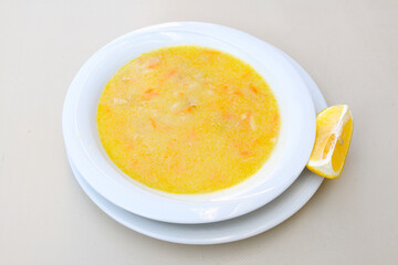 Homemade turkish soup Tavuk Suyu corbasi in a white ceramic soup plate.Turkish noodle chicken broth soup on a plate. Turkish meal (sehriyeli tavuk suyu corbasi)
