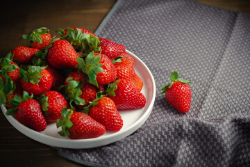 Juicy organic strawberries on gray tablecloth with copy space on background