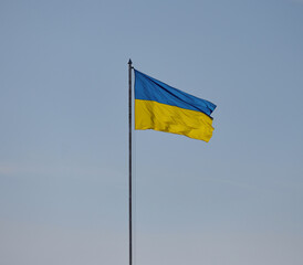 The yellow-blue flag of Ukraine is flying against the blue sky