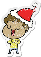 laughing hand drawn distressed sticker cartoon of a man wearing santa hat