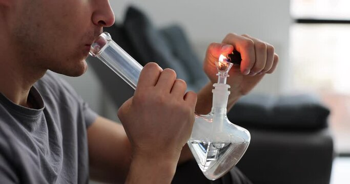 Man smokes using bong and medical marijuana. Lifestyle and concepts of marijuana legalization in world and USA