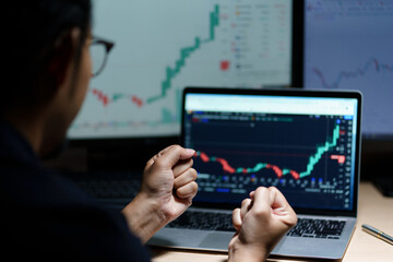 Successful Businessman Sitting at Desk Using Laptop Computer, Celebrate Success. Entrepreneur in Suit working with Stock Market App Smiles, Happy Victory. Motion Blur Background.