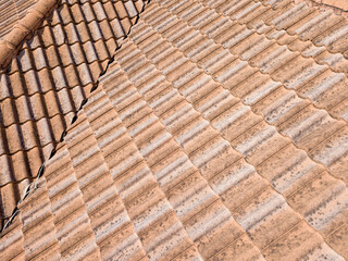 Close up of brown clay roof tiles. Red old dirty roof. Old roof tiles. Construction equipment build a house.