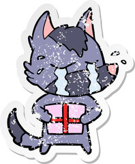 distressed sticker of a cartoon crying wolf with christmas present