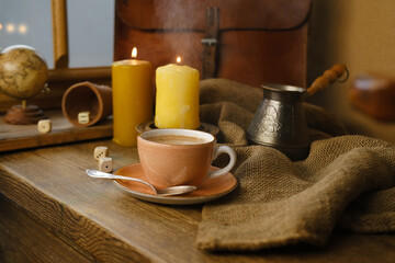 cup with drink coffee on old vintage wooden table, metal coffee maker, candles burn, caffeine improves functioning of human brain, stimulates nervous system, health benefits and harms, copy space