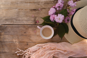 cup with drink coffee cappuccino, hot chocolate with milk, light sunhat, pink sakura flowers, caffeine improves functioning of human brain, stimulates nervous system, health benefits and harms
