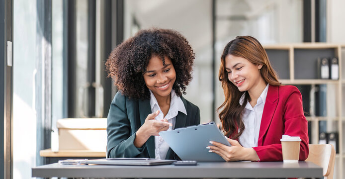 Two business people talk project strategy at office meeting room. Businessman discuss project planning with colleague at modern workplace while having conversation and advice on financial data report.