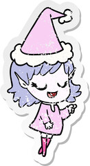 happy hand drawn distressed sticker cartoon of a elf girl pointing wearing santa hat