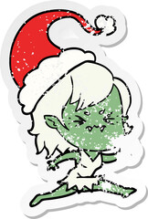 annoyed hand drawn distressed sticker cartoon of a vampire girl wearing santa hat