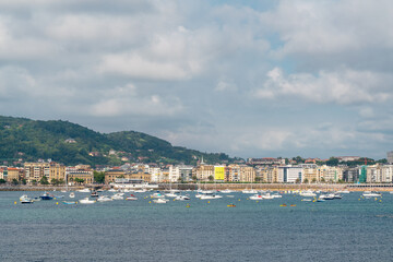 Fototapeta premium SAN SEBASTIAN, Spain July 08 2022: Beautiful San Sebastian - Donostia city. Situated in north of Spain, Basque Country. Famous travel destination. View of La Concha Bay. People at the beach. 
