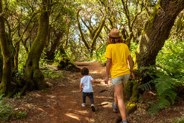 Mother and son walking in La Llania on El Hierro, Canary Islands. On a path of laurel from El Hierro in a lush green landscape
